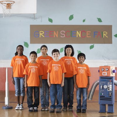 Students in the Science Club standing under the sign Green Science Fair in a school